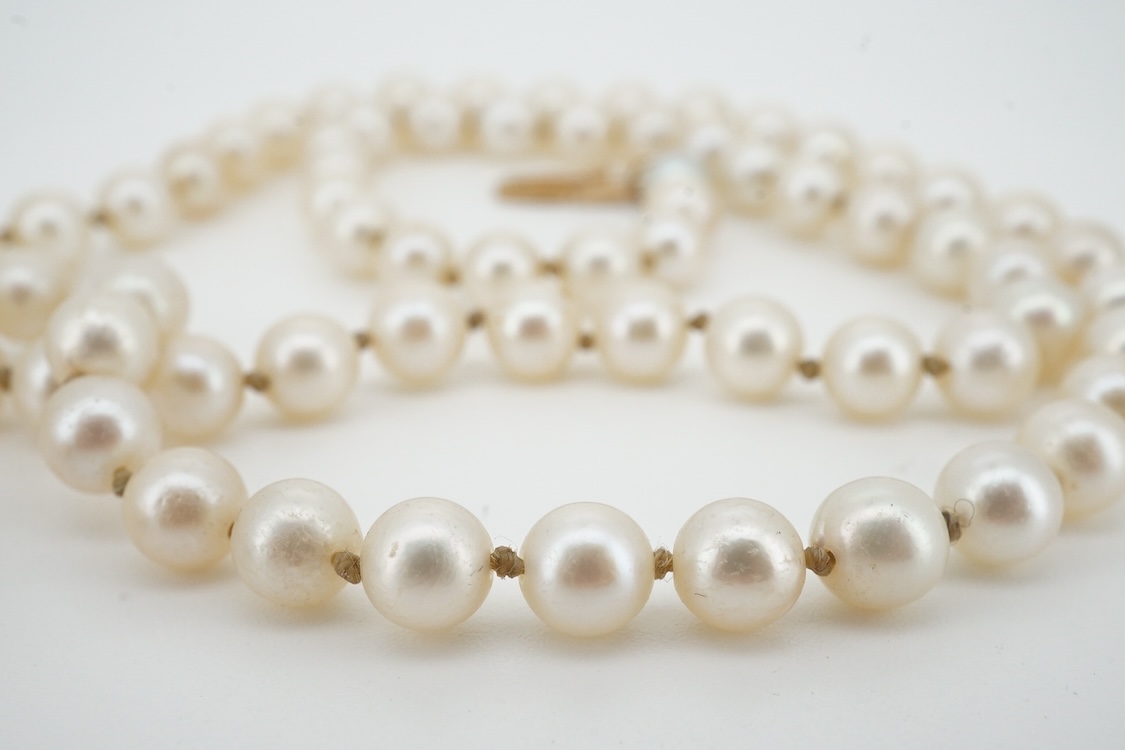A cultured pearl and aquamarine necklace, composed of a single strand of cultured pearls, to a gold clasp set with an oval aquamarine, length 53.5cm, Condition: in good condition, minor wear, minor variations in pearl co